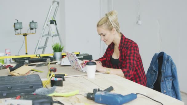 Sitter vid arbetsbänken kvinna använder laptop — Stockvideo
