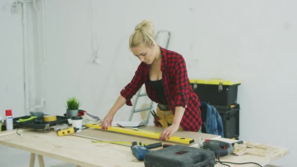 Frau benutzt Wasserwaage auf Werkstatttisch — Stockvideo