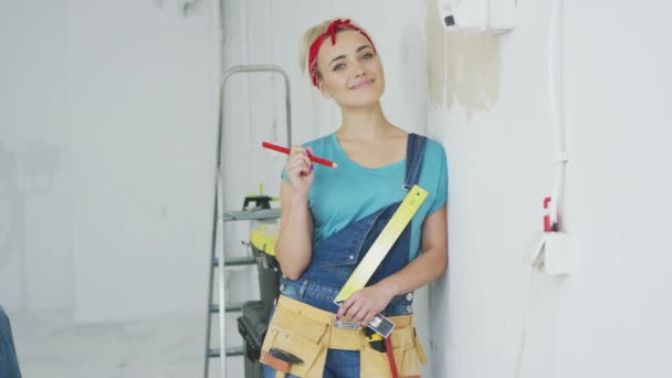 Χαμογελαστή γυναίκα ξυλουργός ακουμπά στον τοίχο — Αρχείο Βίντεο