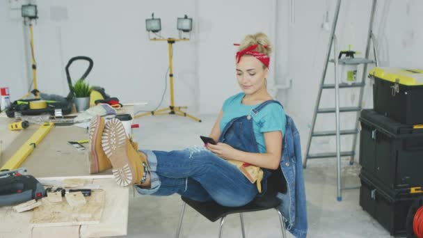Γυναίκα αναπαύεται με smartphone στο πάγκο εργασίας ξυλουργός — Αρχείο Βίντεο