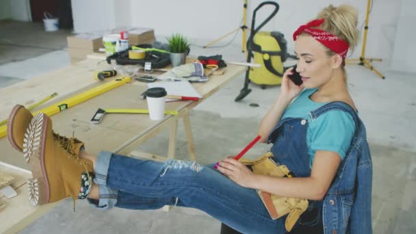 Female carpenter at workplace talking on smartphone — Stock Video