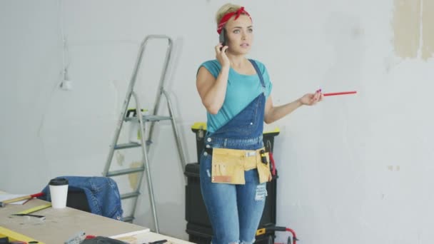 Doing home repairs woman talking on smartphone — Stock Video