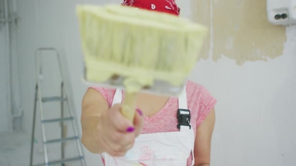 Щаслива жінка-художник вказує пензлем — стокове відео