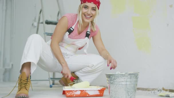 Sorrindo feminino mergulhando rolo de pintura na bandeja — Vídeo de Stock