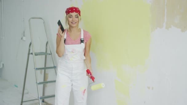 Painting wall woman talking on smartphone — Stock Video