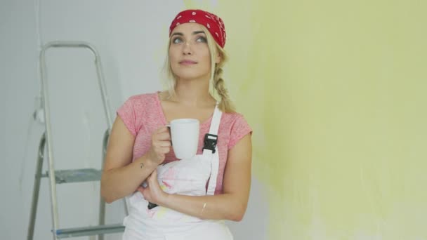 Malířka v kombinéze odpočívá s nápojem — Stock video