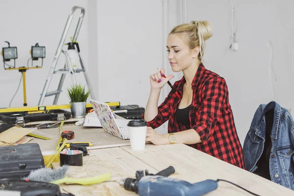 Sitting at workbench female using laptop — Stock Photo, Image