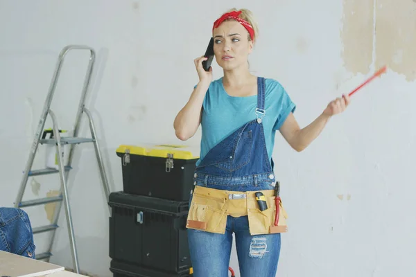 Hausreparaturen: Frau telefoniert mit Smartphone — Stockfoto