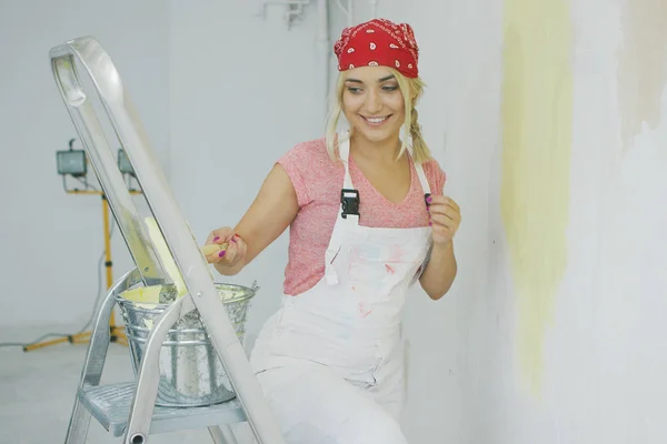 Cepillo de inmersión femenina feliz en pintura de pared —  Fotos de Stock