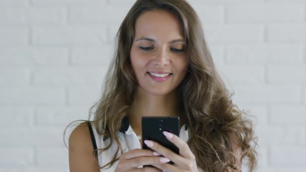 女性与波浪头发浏览智能手机 — 图库视频影像