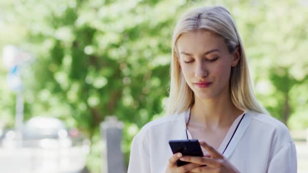 Молода леді використовує смартфон на вулиці — стокове відео