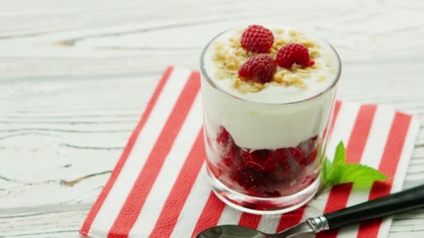 Glass with yogurt and raspberry — Stock Video