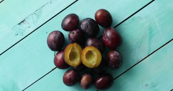 Pile of ripe plums on blue wood — Stock Video