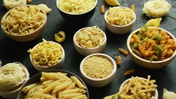 Diferentes tipos de macarrones puestos en cuencos — Vídeos de Stock