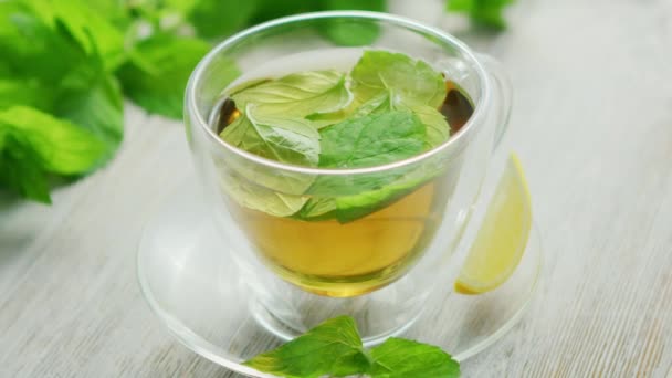 Cup of green tea with mint and lemon — Stock Video