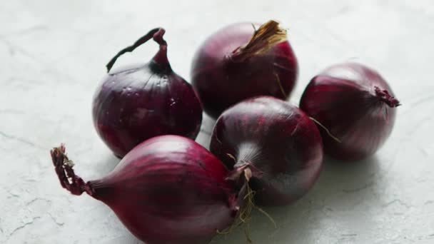 Bombillas de cebolla roja sobre mesa blanca — Vídeo de stock