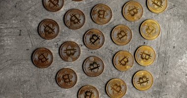 Golden bitcoins on gray surface clipart