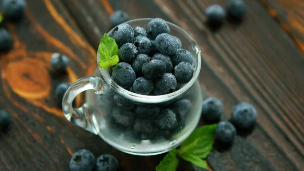 Tasse pleine de bleuets à feuilles vertes — Photo