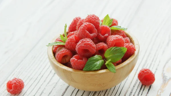 Bowl with raspberries and leaves — Stock Photo, Image