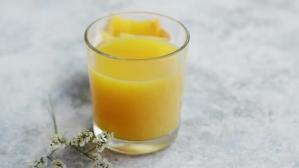 Ένα ποτήρι φρέσκο χυμό πορτοκαλιού — Αρχείο Βίντεο