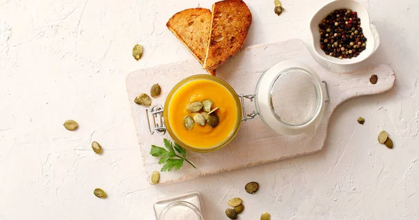 Soupe de citrouille dans un bocal en verre sur planche à découper — Photo