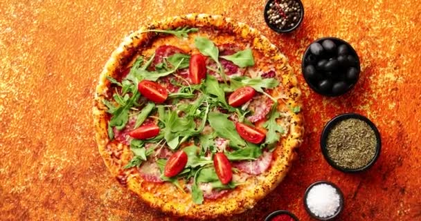 Tasty pizza on a rusty background with spices, herbs and vegetables — Stock Video