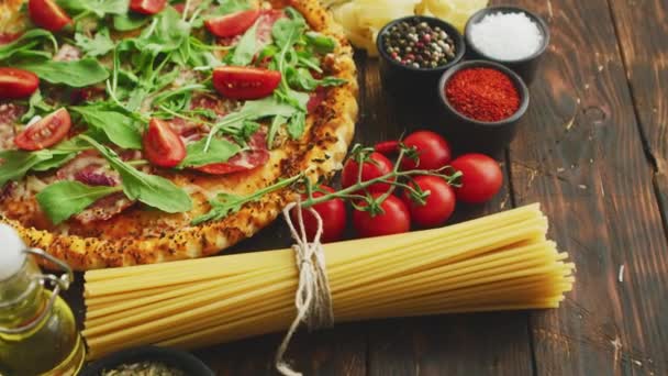 Italian food background with pizza, raw pasta and vegetables on wooden table — Stock Video