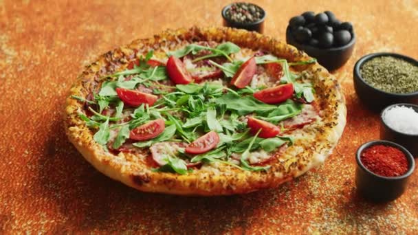 Välsmakande pizza på en rostig bakgrund med kryddor, örter och grönsaker — Stockvideo