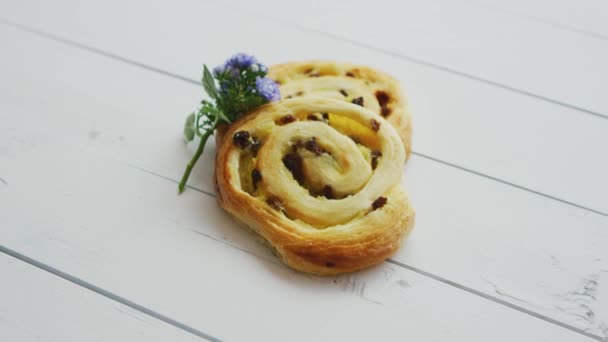 Deliciosa pastelería con pasas sobre mesa de madera blanca — Vídeos de Stock