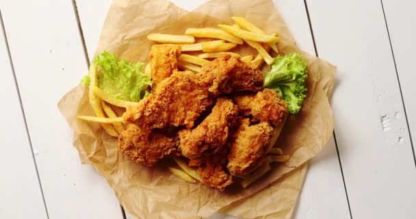 Lattuga e patatine fritte vicino alle ali di pollo — Video Stock