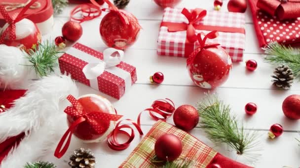 Хвойные ветки и безделушки возле рождественских подарков — стоковое видео