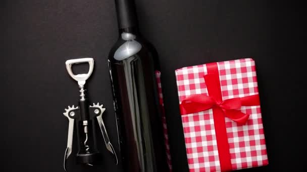 Rotweinflasche, Korkenzieher und verpacktes Weihnachtsgeschenk — Stockvideo