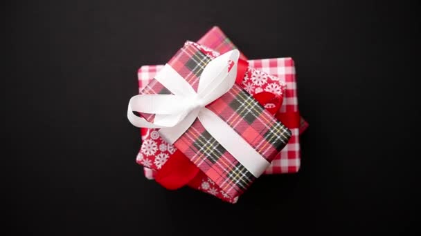 Caja de regalo roja con lazo rojo sobre mesa negra, vista superior — Vídeo de stock
