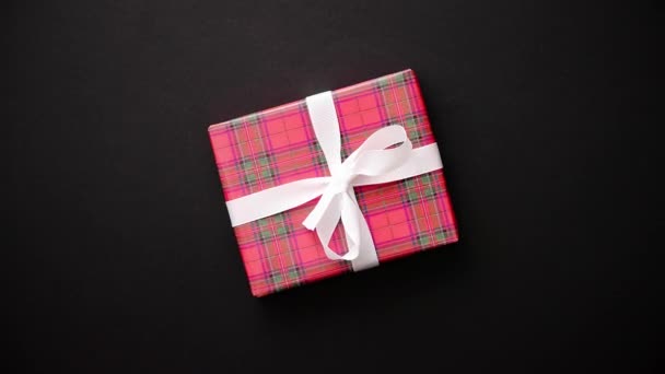 Siyah tablo, üstten görünüm üzerinde beyaz fiyonklu kırmızı hediye kutusu — Stok video