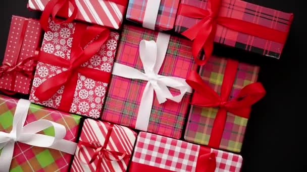 Вид сверху упакованных рождественских подарков на чёрном фоне — стоковое видео