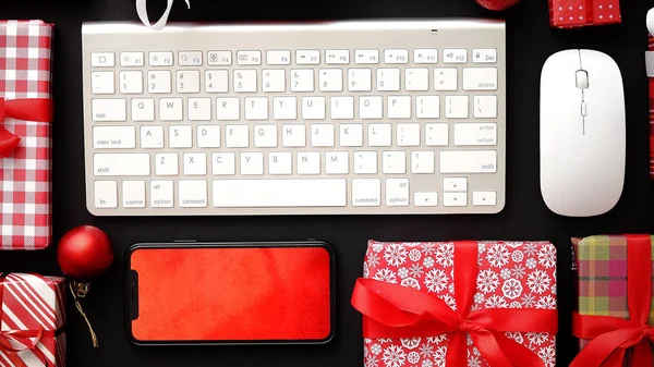 Teclado de ordenador, smartphone moderno, ratón y regalos en caja de Navidad — Foto de Stock