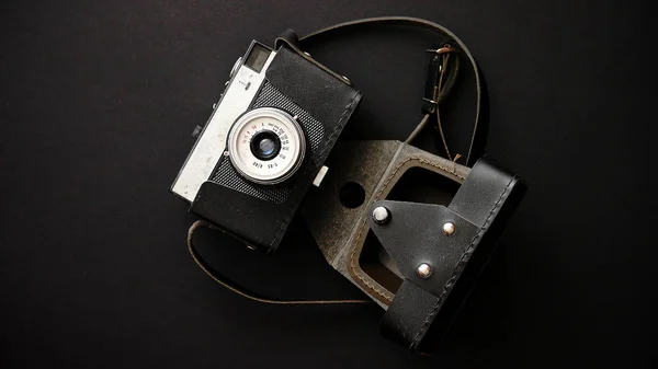 Старая ретро-камера в кожаном чехле на черном фоне — стоковое фото