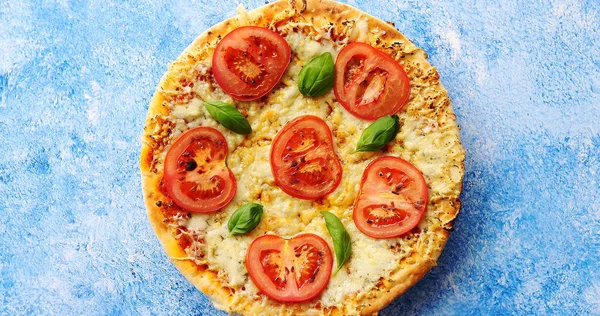 Pizza z serem i pomidorami na niebieski kamień tabeli — Zdjęcie stockowe