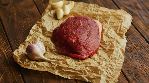 Bawang putih dan daging di atas perkamen — Stok Foto