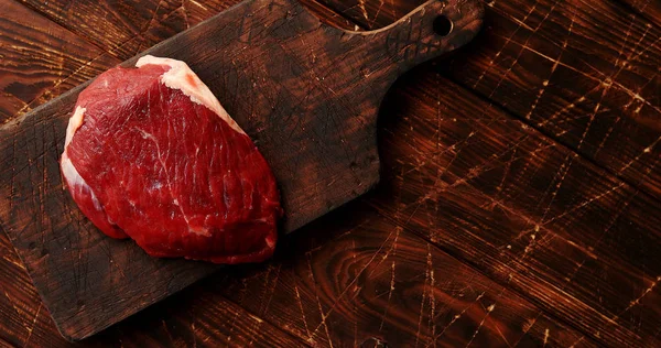 Daging mentah di atas papan pemotong — Stok Foto