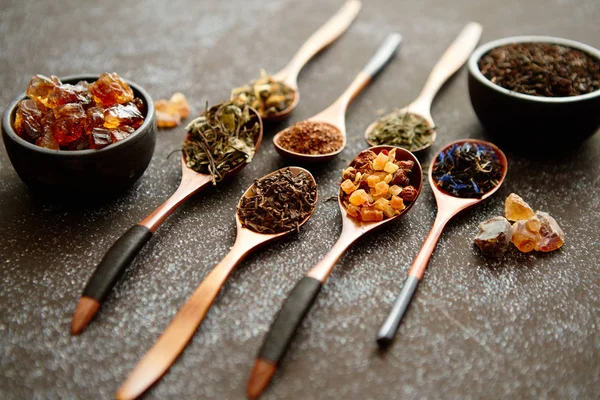 Cuillères avec différents types de feuilles de thé sèches . — Photo