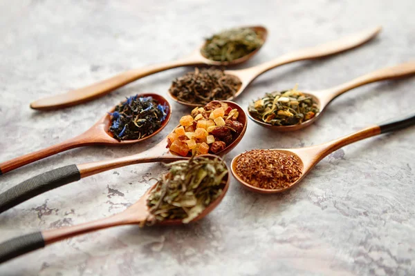 Virious druhů čaje v dřevěné lžíce na kamenný stůl — Stock fotografie