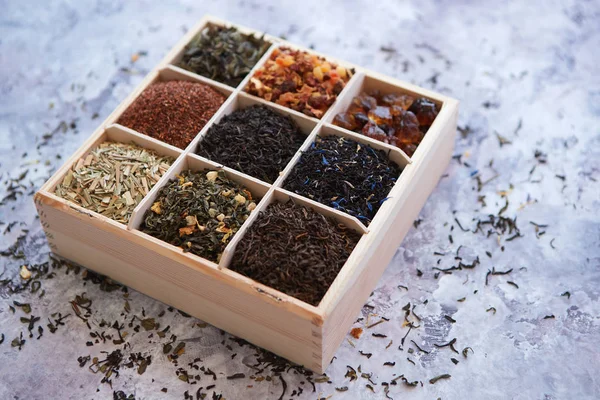 Divers types de thé sec dans une boîte en bois — Photo