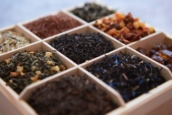 Divers types de thé sec dans une boîte en bois — Photo