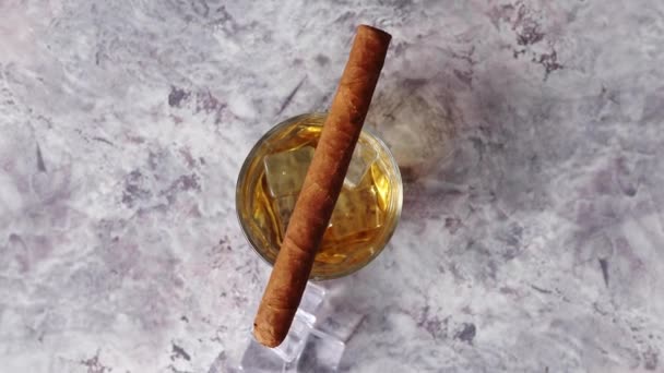 Glas whiskey med isbitar och cigarr — Stockvideo