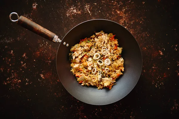 Riz épicé frit traditionnel avec poulet servi dans un wok en fer rond — Photo