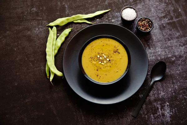 Creamy soup with green pea in a ceramic white plate — Stock Image Creamy soup with green pea in a ceramic white plate Stock Photo