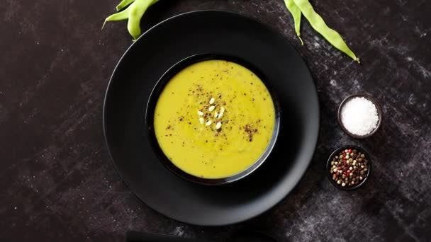 Сливочный суп с зеленым горошком в керамической белой тарелке — стоковое видео
