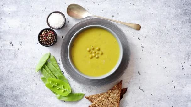 Sopa de crema de guisantes verdes en tazón gris — Vídeos de Stock