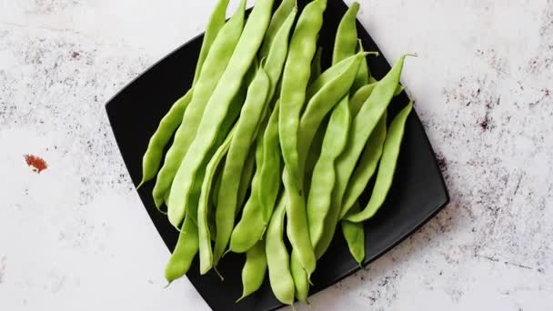 新鮮な緑の豆の莢を持つ黒セラミック プレート — ストック動画